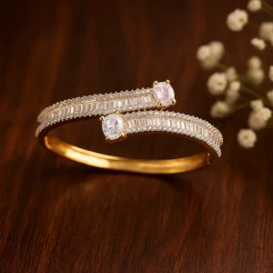 Dual stone baguette diamond bracelet in gold finish with pink and white crystal detailing for modern festive wear